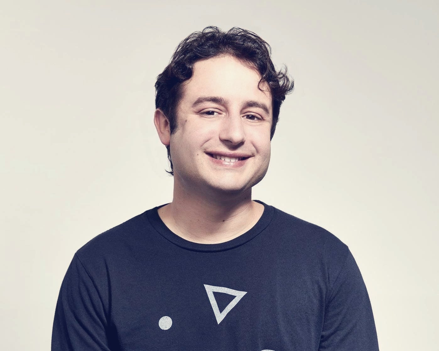 Dylan Field, Figma cofounder and CEO, seated and smiling against a plain wall