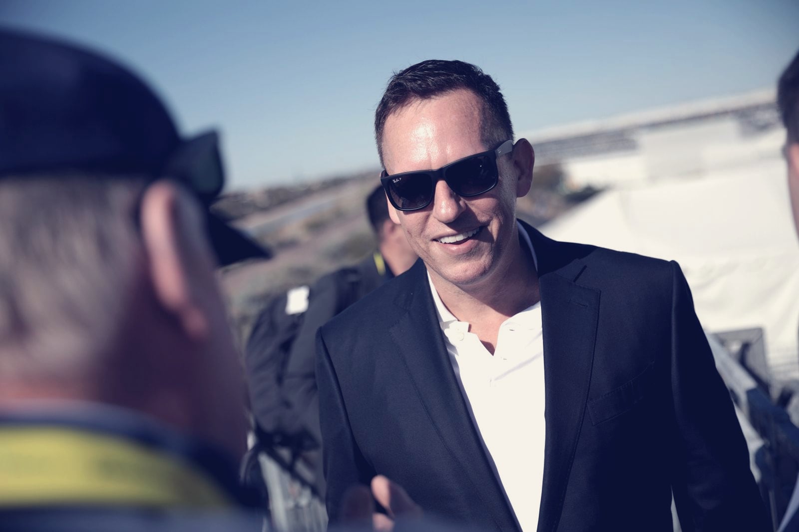 Context image: Peter Thiel, founder of the Thiel Fellowship, speaking with attendees at a 2022 technology summit in Scottsdale, Arizona. He is not shown with any fellow.